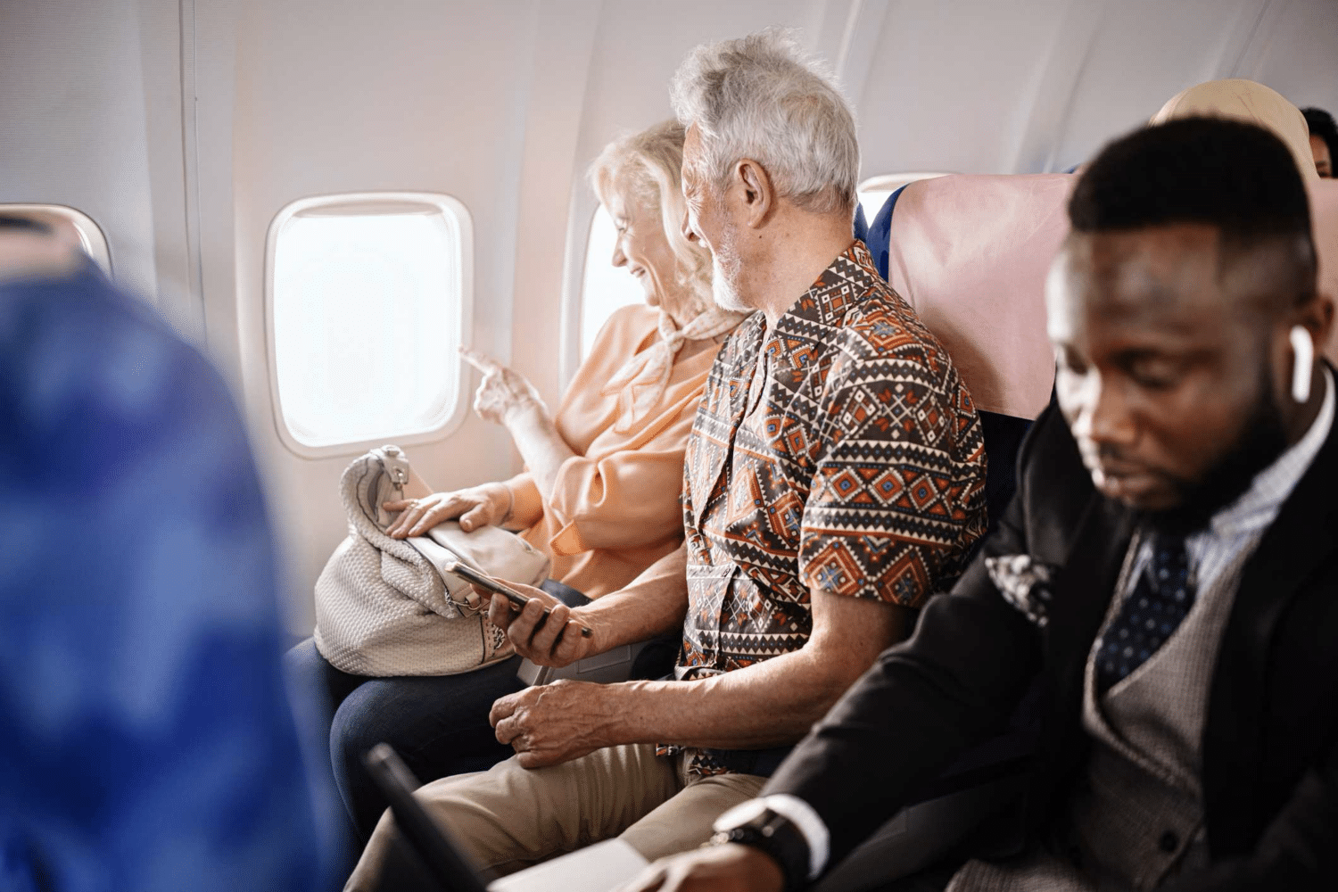 An older New York man who suffers from hearing loss traveling on an airplane with his wife.