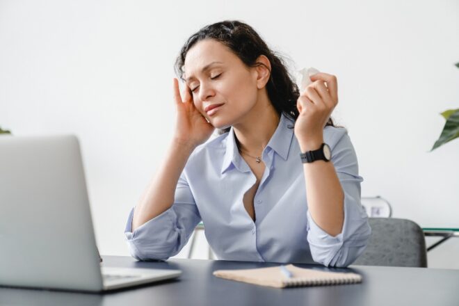 A woman suffers ear pain while working in her New York office.